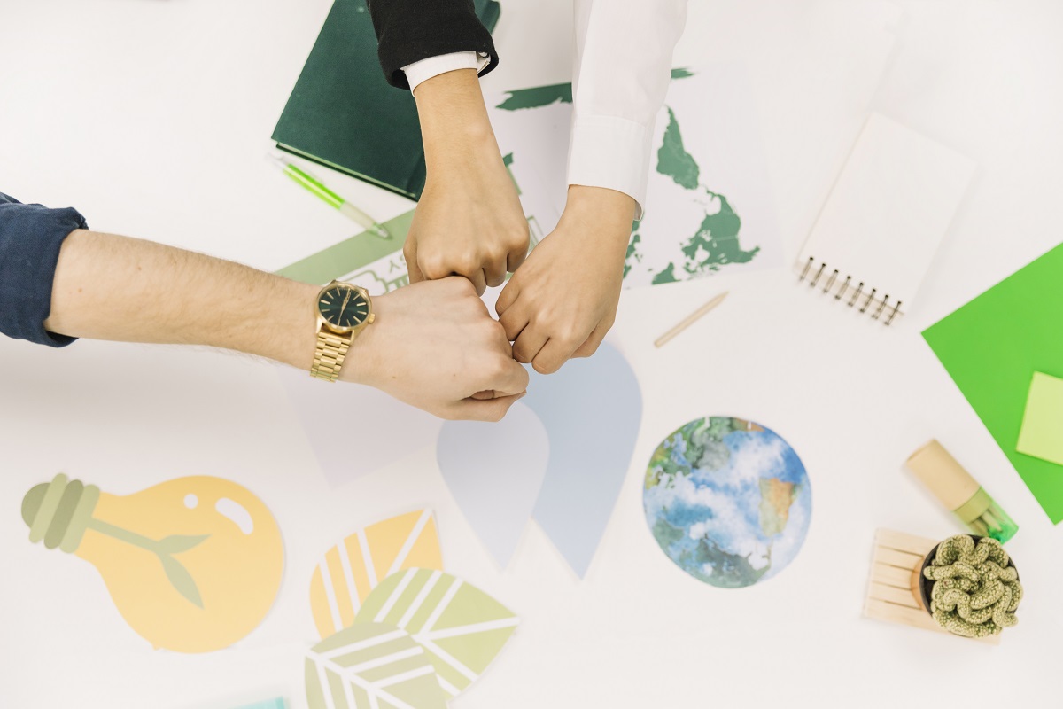 Group businesspeople fist bumping desk upravený